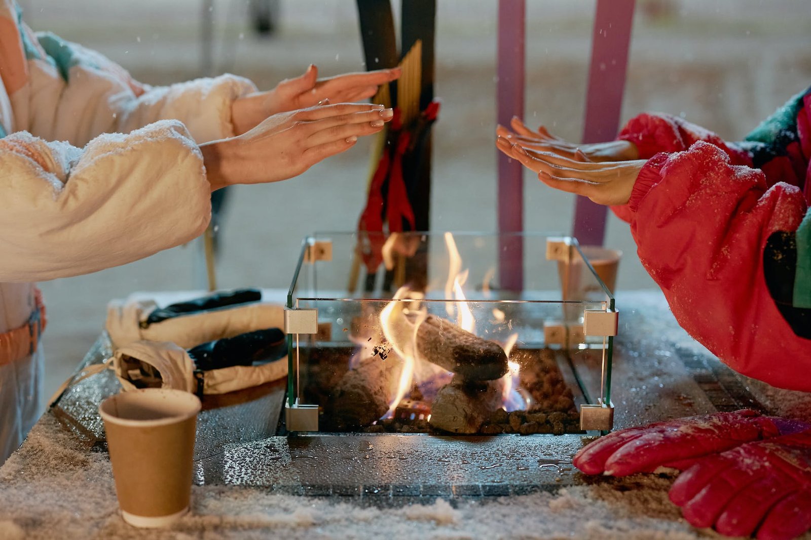 two women warming hands on fire